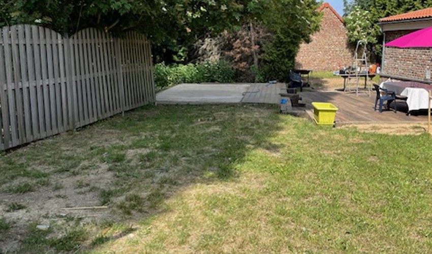 "Jardin propre et dégagé après l’évacuation complète des encombrants par un service de débarras en Belgique, avec pelouse visible et terrasse en bois nettoyée.